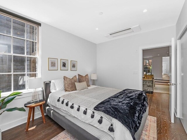 bedroom featuring multiple windows and dark hardwood / wood-style floors