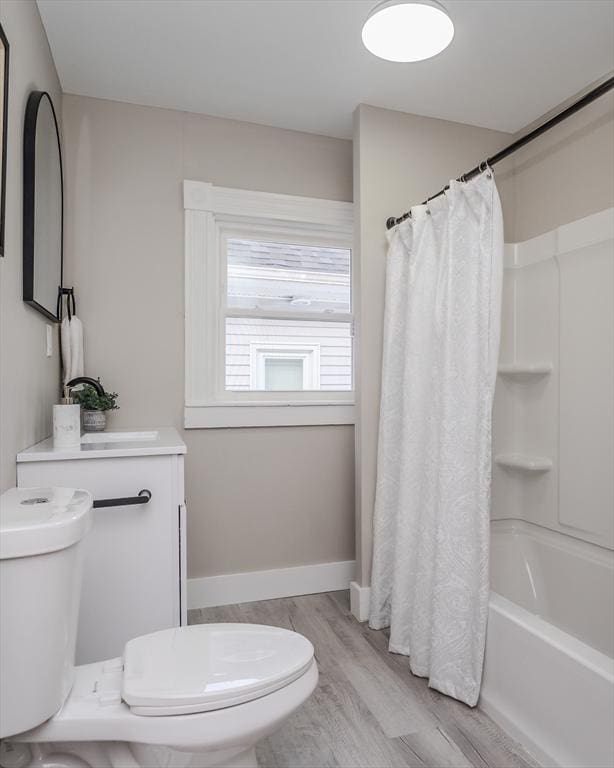 full bathroom with toilet, hardwood / wood-style floors, vanity, and shower / tub combo with curtain