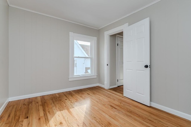 spare room featuring light hardwood / wood-style floors and ornamental molding