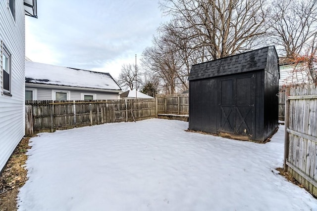 yard layered in snow featuring a storage unit