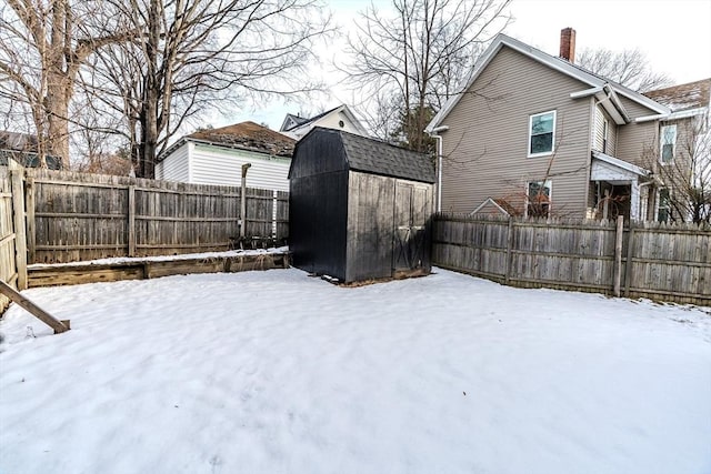 yard covered in snow featuring a storage unit