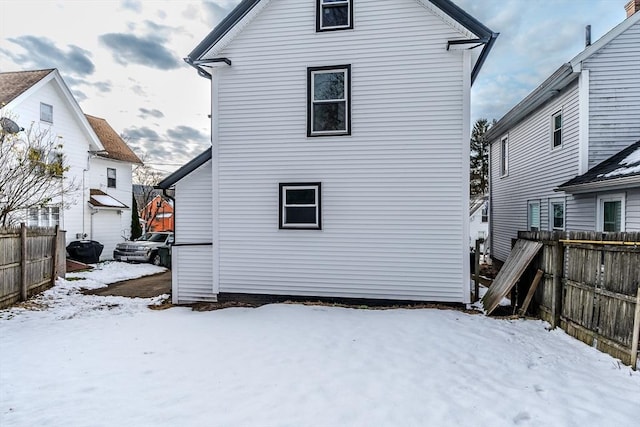 view of snow covered back of property