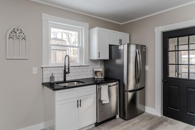 kitchen with plenty of natural light, white cabinetry, sink, and appliances with stainless steel finishes