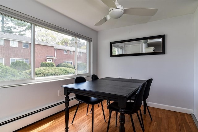 dining area featuring baseboards, ceiling fan, baseboard heating, and hardwood / wood-style floors