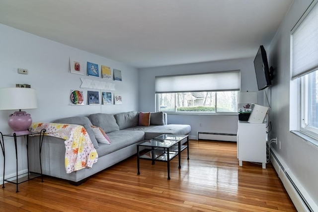 living area with a baseboard radiator and light wood finished floors