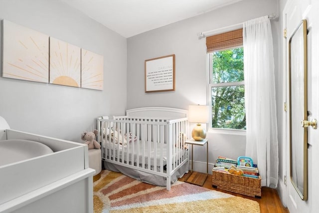 5 Hinckley St Unit 2, Somerville, MA 02145 - bedroom featuring wood finished floors and a crib