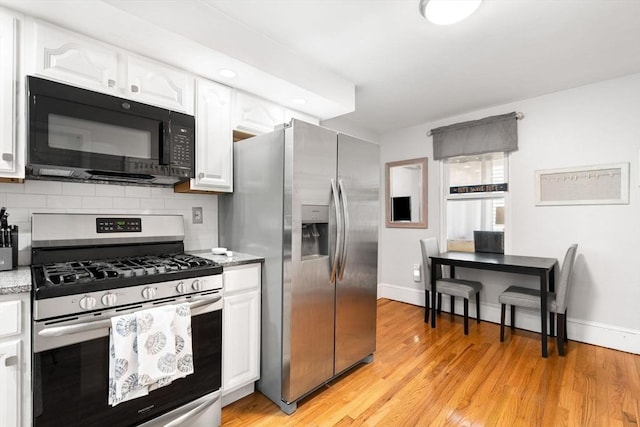 5 Hinckley St Unit 2, Somerville, MA 02145 - kitchen featuring stainless steel appliances, white cabinets, light wood-style flooring, and light stone countertops