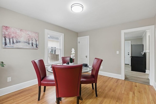 dining area featuring light wood-style flooring and baseboards