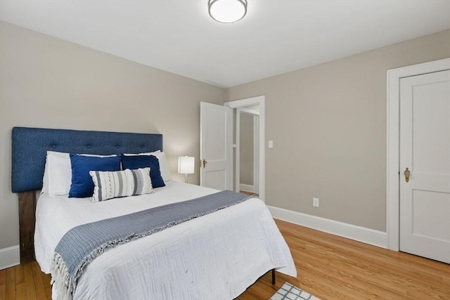 bedroom featuring baseboards and wood finished floors