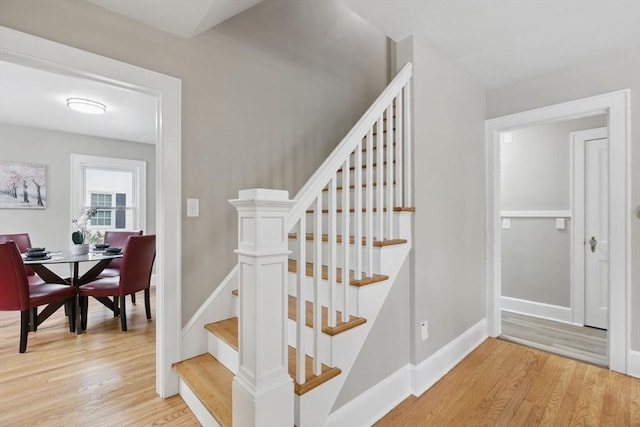 stairway with baseboards and wood finished floors