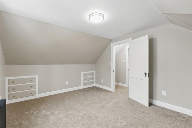 bonus room with vaulted ceiling, carpet floors, and baseboards