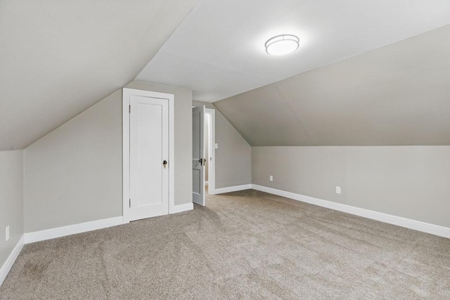 bonus room featuring lofted ceiling, carpet flooring, and baseboards