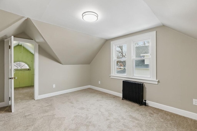 additional living space with carpet, radiator heating unit, baseboards, and vaulted ceiling