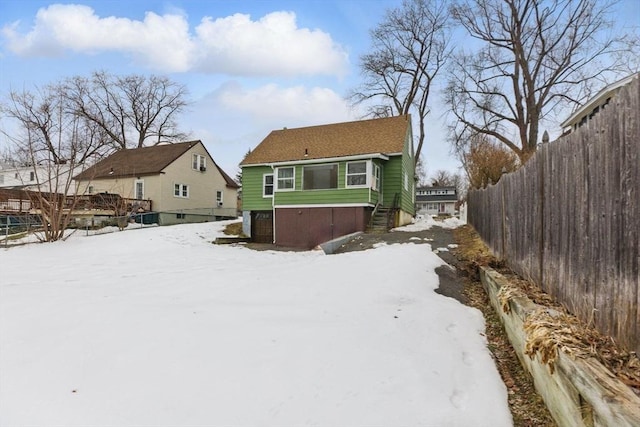 snow covered house with fence