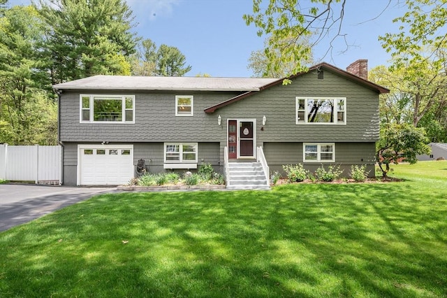 4 Pleasantview Ave, Tyngsborough, MA 01879 - bi-level home with a garage, a chimney, and driveway