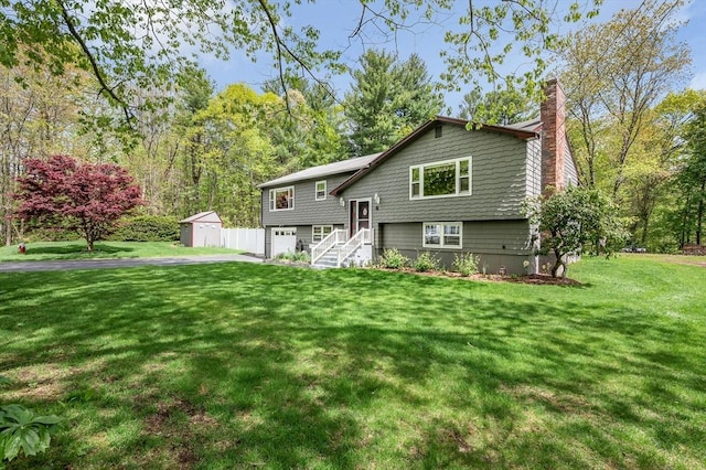 4 Pleasantview Ave, Tyngsborough, MA 01879 - rear view of house with a chimney, a garage, a shed, driveway, and a lawn