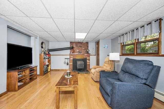 4 Pleasantview Ave, Tyngsborough, MA 01879 - living room featuring a drop ceiling, a baseboard radiator, wood finished floors, a wood stove, and baseboards
