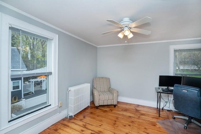 office space featuring wood finished floors, radiator, ceiling fan, ornamental molding, and baseboards