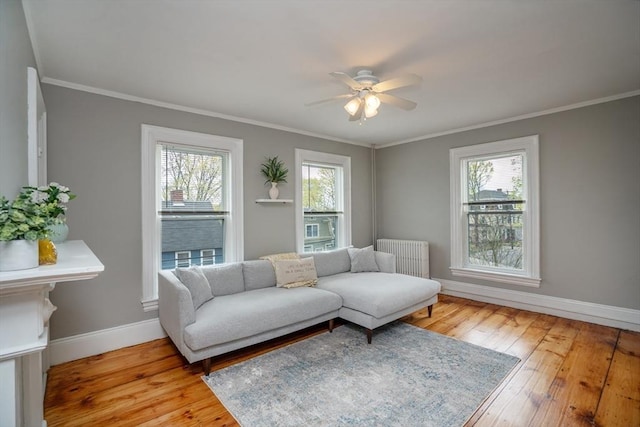 living area featuring baseboards, radiator heating unit, a wealth of natural light, and ceiling fan