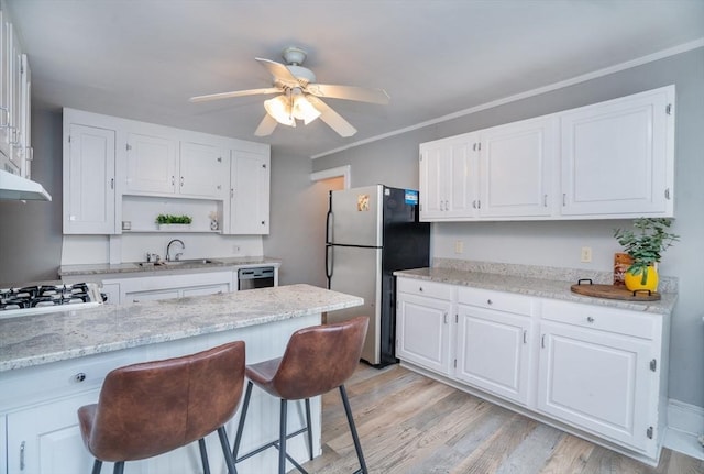 kitchen with stainless steel appliances, open shelves, white cabinets, and a sink