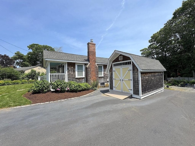 15 Wales Dr, Bourne, MA 02559 - view of front of property featuring a storage unit, a gambrel roof, and a chimney