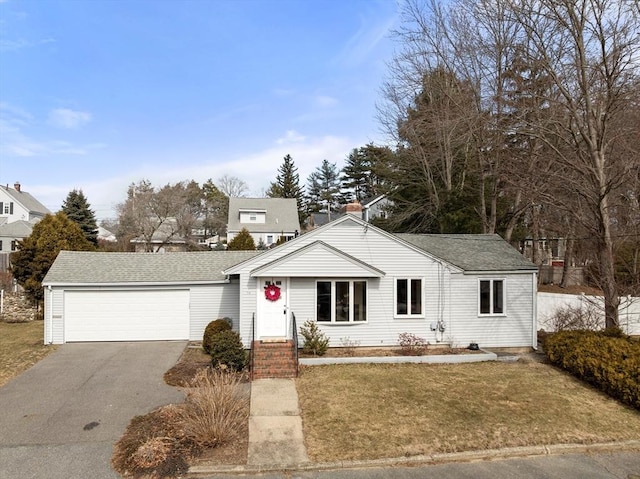 view of front facade featuring a front lawn, an attached garage, driveway, and a shingled roof