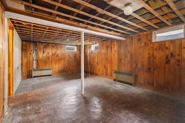 basement with wooden walls and radiator heating unit