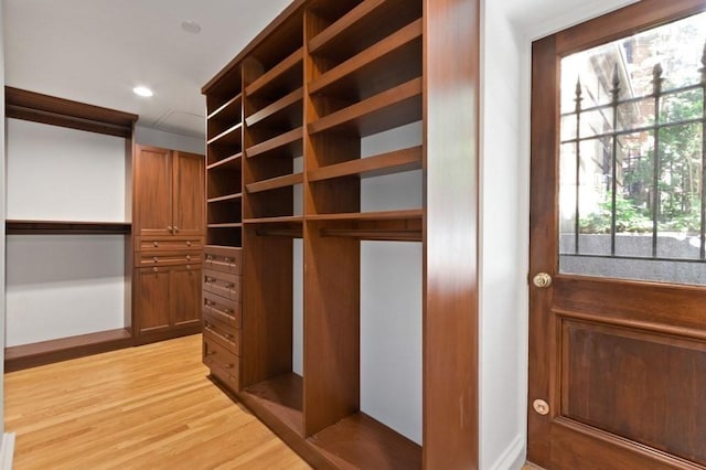 walk in closet with light hardwood / wood-style floors