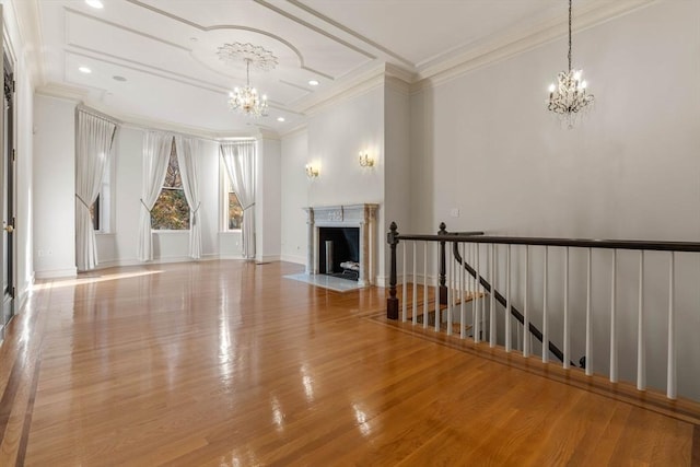 unfurnished living room with a premium fireplace, crown molding, and light hardwood / wood-style flooring