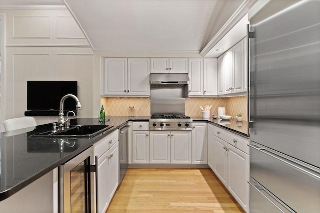 kitchen featuring stainless steel appliances, beverage cooler, sink, light hardwood / wood-style floors, and white cabinetry