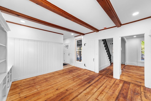 unfurnished living room featuring hardwood / wood-style flooring and beam ceiling