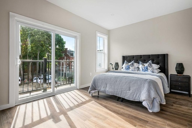 bedroom featuring access to exterior and hardwood / wood-style floors