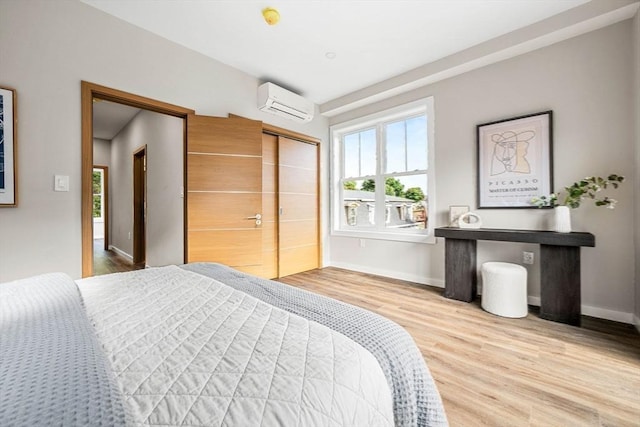 bedroom featuring hardwood / wood-style floors, a wall mounted air conditioner, and a closet