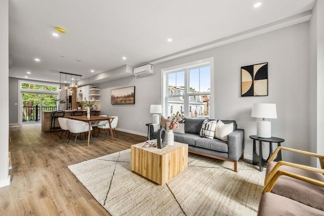 living room featuring a wall mounted AC and hardwood / wood-style floors