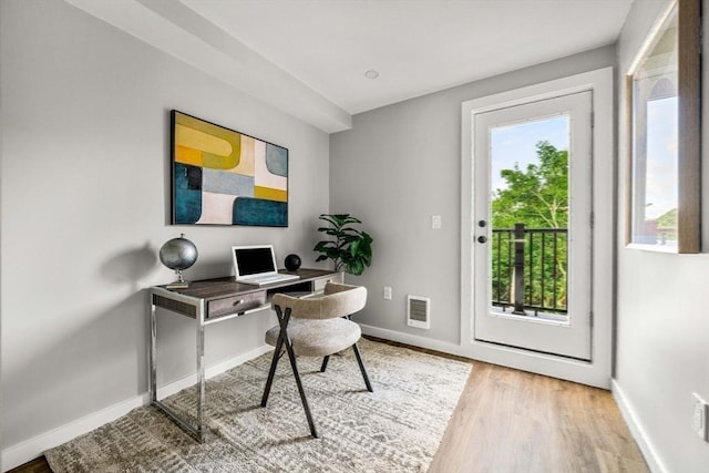 home office with light hardwood / wood-style floors