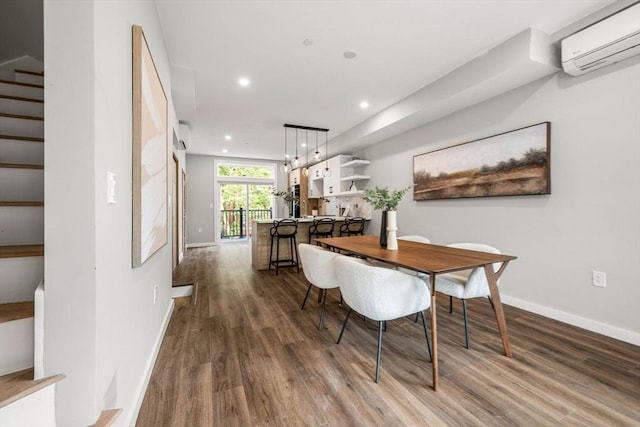 dining area with hardwood / wood-style flooring and a wall mounted air conditioner