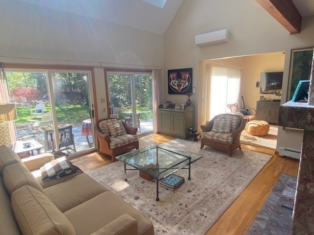 living room featuring a wall mounted AC, beam ceiling, hardwood / wood-style flooring, a skylight, and baseboard heating