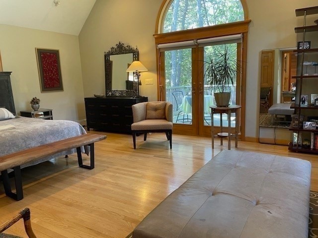 bedroom featuring light hardwood / wood-style flooring, french doors, high vaulted ceiling, and access to outside