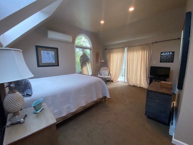 carpeted bedroom with lofted ceiling with skylight and a wall mounted AC