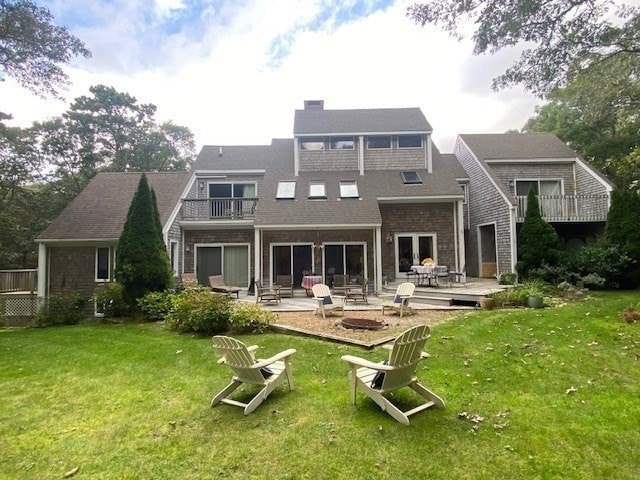 back of house featuring a yard, a patio, and a balcony