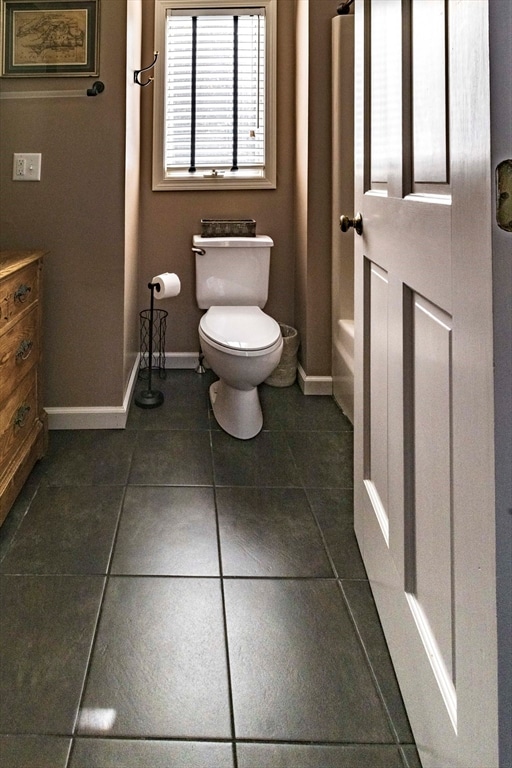 bathroom with toilet, vanity, a washtub, and tile patterned flooring