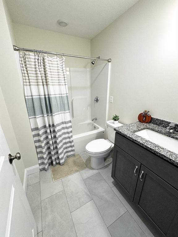 full bathroom featuring vanity, shower / bath combination with curtain, and toilet