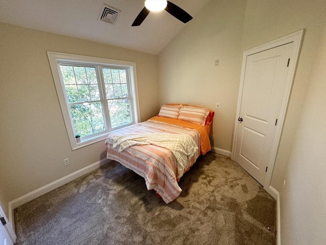 bedroom with ceiling fan, lofted ceiling, and dark colored carpet