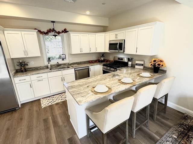 kitchen with white cabinets, kitchen peninsula, sink, and appliances with stainless steel finishes