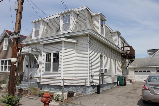143 Branch St, Lowell, MA 01851 - view of home's exterior featuring a garage, a shingled roof, asphalt driveway, and mansard roof