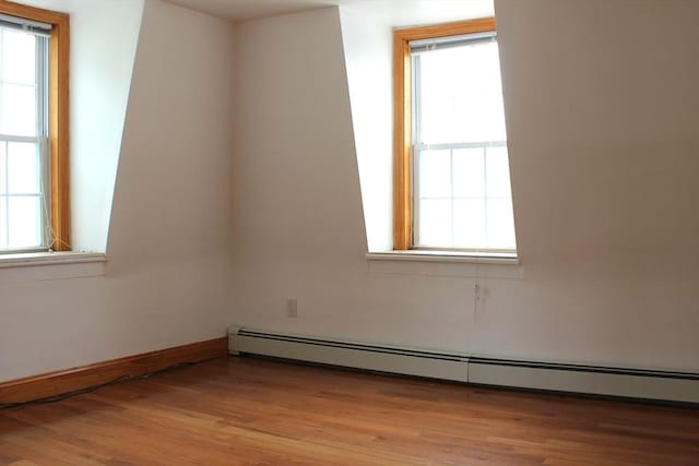 143 Branch St, Lowell, MA 01851 - spare room featuring a baseboard heating unit, healthy amount of natural light, and light wood finished floors