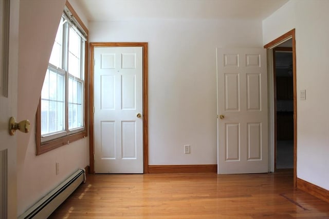 143 Branch St, Lowell, MA 01851 - unfurnished bedroom with a baseboard radiator, light wood finished floors, and baseboards