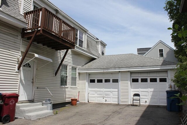 143 Branch St, Lowell, MA 01851 - view of side of property with entry steps, asphalt driveway, an attached garage, and a shingled roof