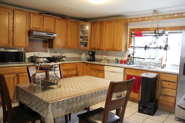 143 Branch St, Lowell, MA 01851 - kitchen with under cabinet range hood, white dishwasher, a sink, light tile patterned flooring, and light countertops