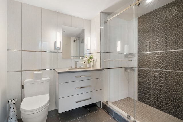 bathroom with tile patterned flooring, vanity, toilet, and tile walls